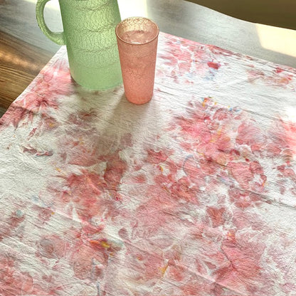 Pink and white marbled tea towel with a green pitcher and pink glass on top