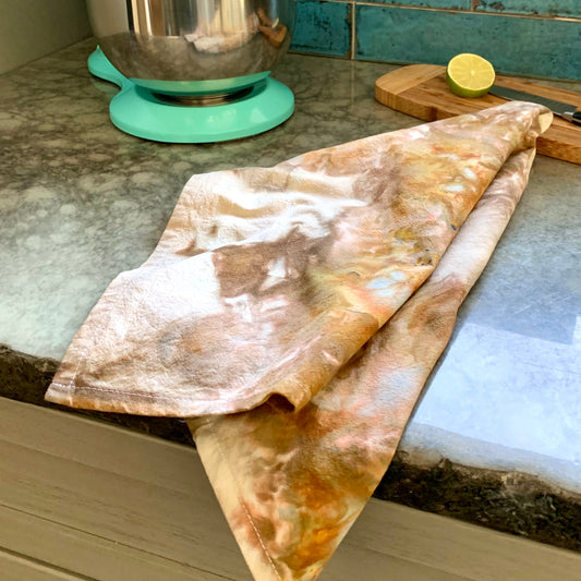 Hand-dyed brown tea towel from Astilbe Lane, shown on kitchen counter.